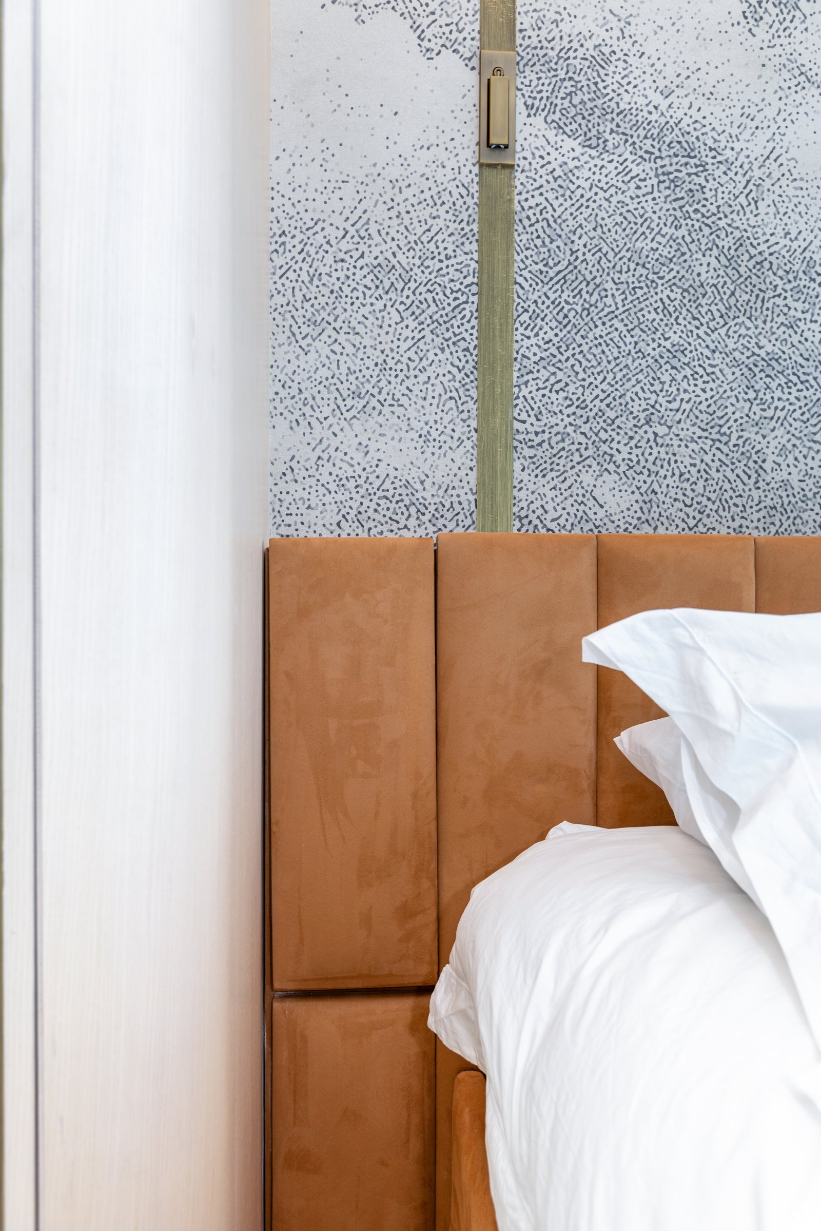 Bedroom detail with upholstered headboard and textured wallpaper, £4 million apartment, Vauxhall, styled by Aire Interiors