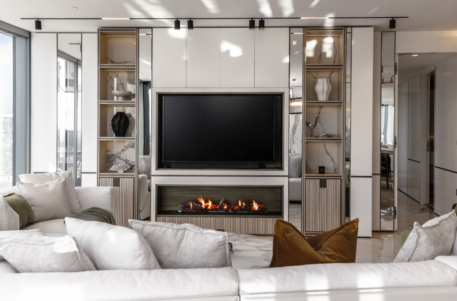 Fireplace and media wall with olive velvet seating, £4 million apartment, Vauxhall, styled by Aire Interiors