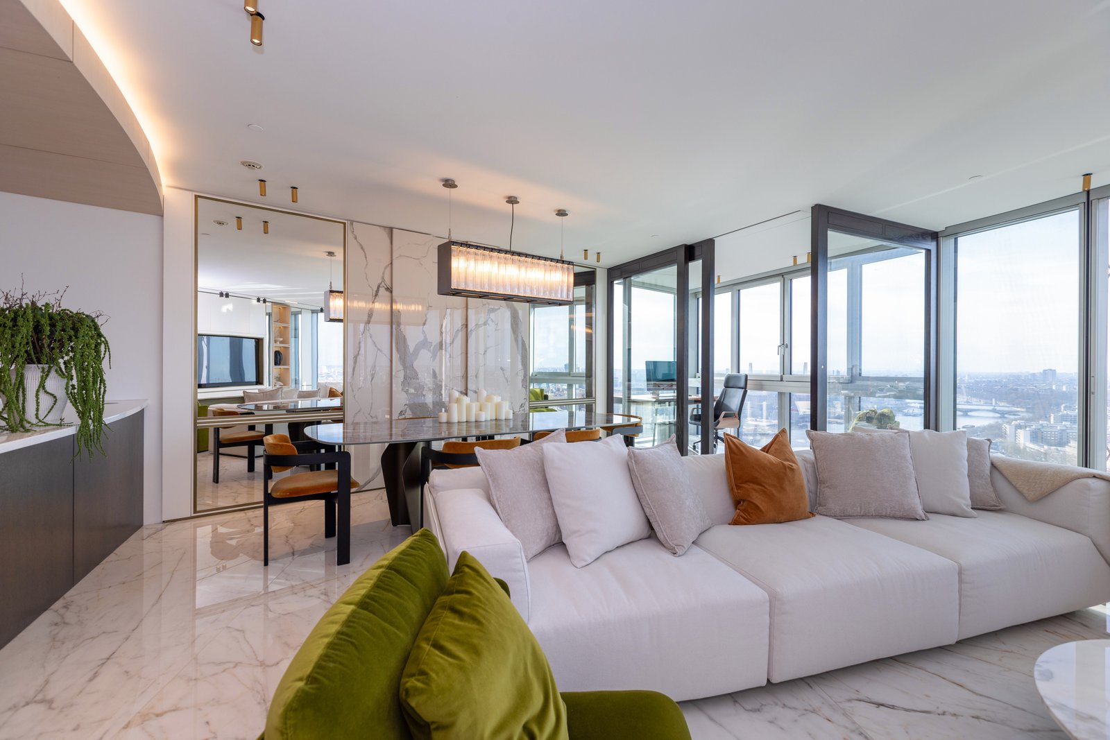 Open plan living and dining space with floor to ceiling windows over the London skyline, £4 million apartment, Vauxhall, styled by Aire Interiors
